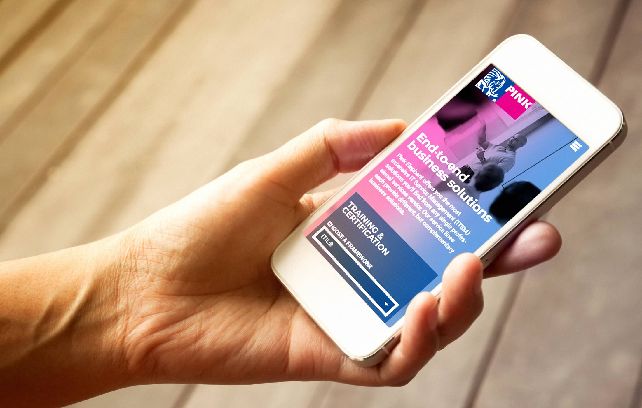 Closeup of a person interacting with the Pink Elephant website on their mobile phone
